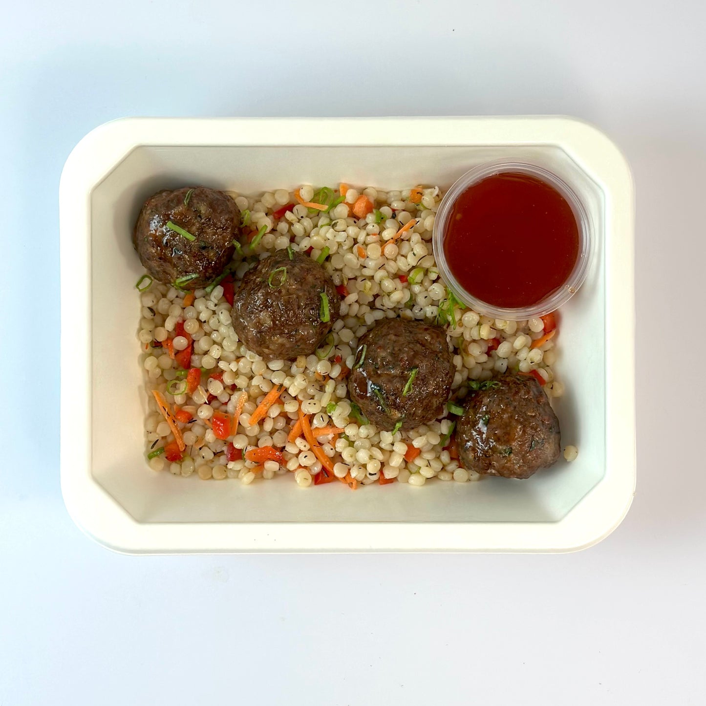 Albóndigas de miel y sriracha con cuscús israelí